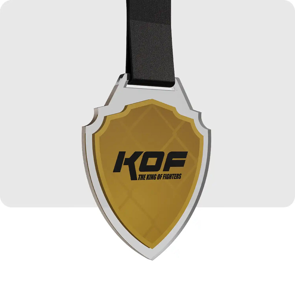 Médaille plastique de couleur jaune et noir, en forme de bouclier avec le nom de l'évènement au centre de la médaille.  