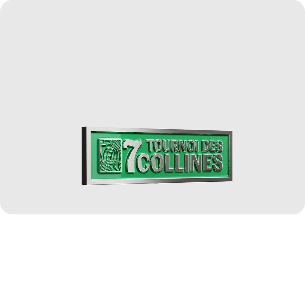 Pin's personnalisé en métal de couleur vert argenté représentant le logo du tournoi de football des 7 collines. 