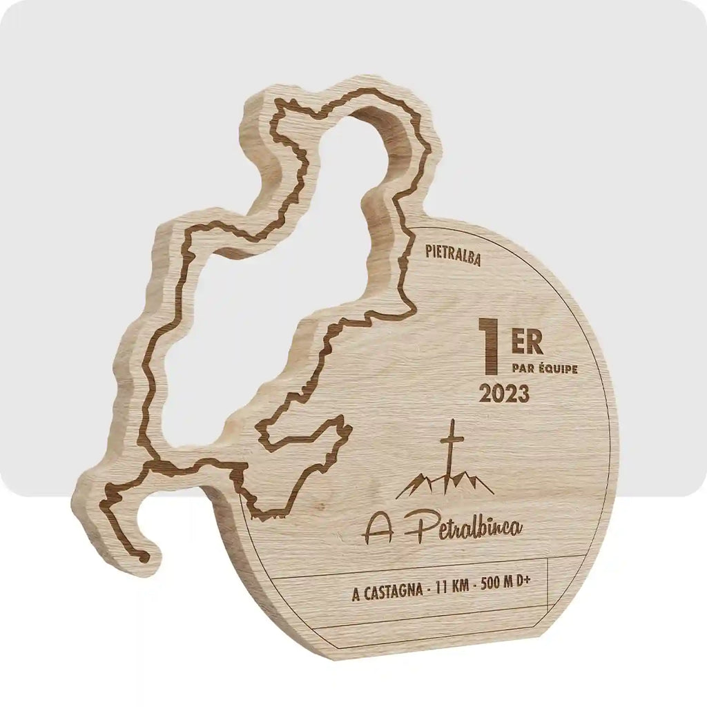 Trophée en bois en forme de cercle, avec le tracé du trail en relief. 