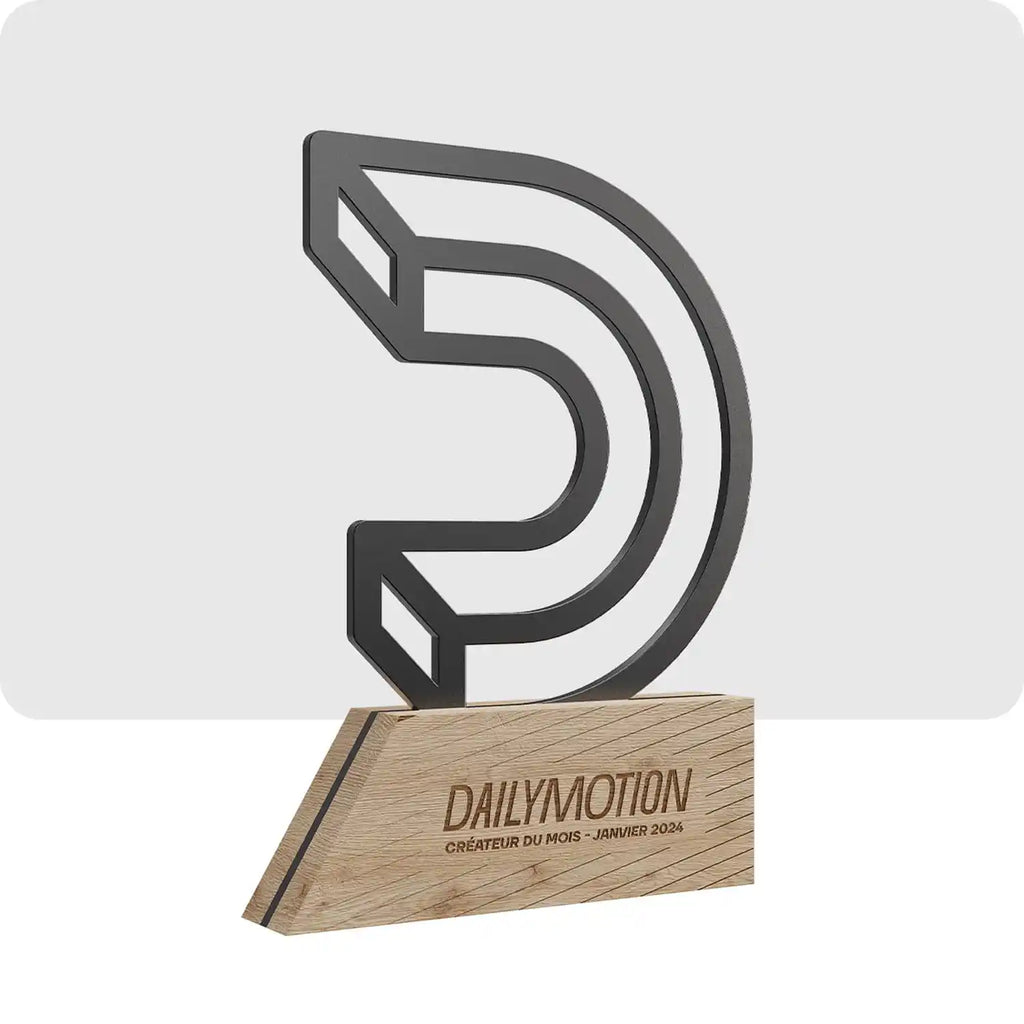 Trophée personnalisé en bois et en métal. Le logo de Dailymotion est en métal et le socle sur lequel il repose est en bois. 