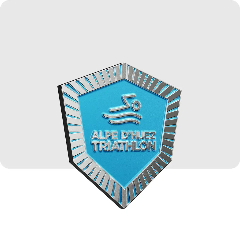 Ce magnet de couleur gris et bleu représente l'épreuve de natation du triathlon de l'Alpe d'Huez.