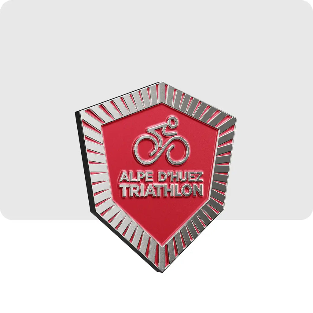 Ce magnet de couleur gris et rouge représente l'épreuve de cyclisme du triathlon de l'Alpe d'Huez.