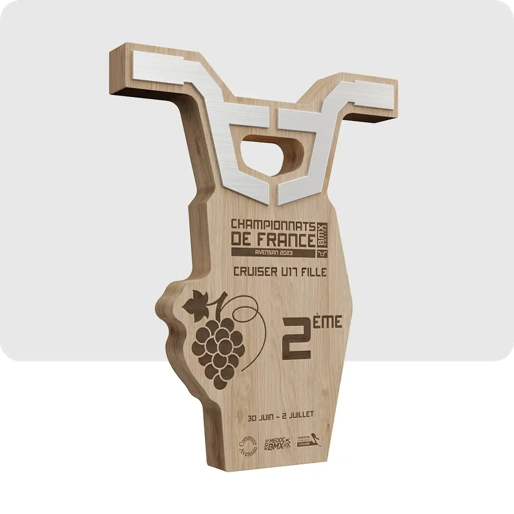 Trophée personnalisé en bois, métal, plexiglass, le haut du trophée est en forme de guidon de BMX et en son centre le nom de la compétition est indiqué.